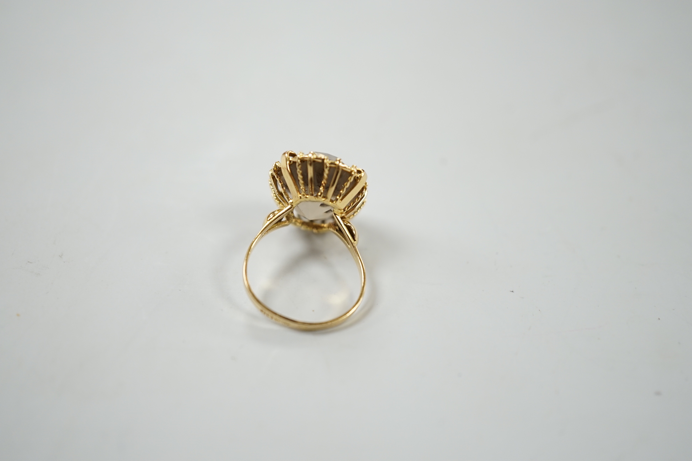 An 18ct and oval cut smoky quartz set dress ring, size G/H, gross weight 3.9 grams.